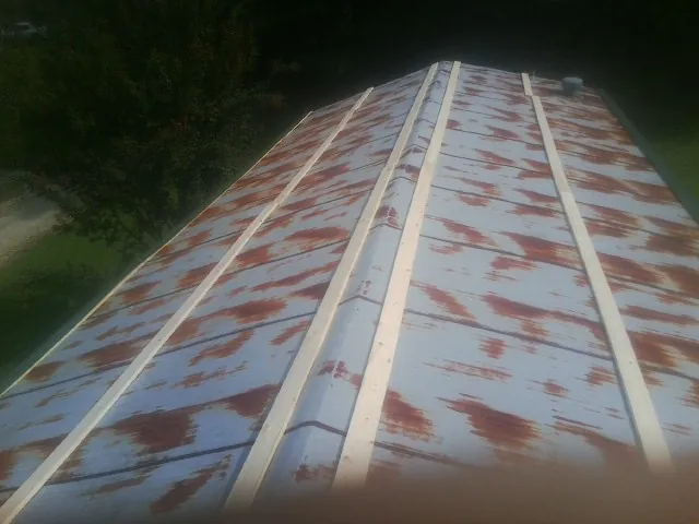 Rusted metal roof panels with new wood purlins before replacement — Storm Damage Roof Repair in Byfield by Roofing Brothers