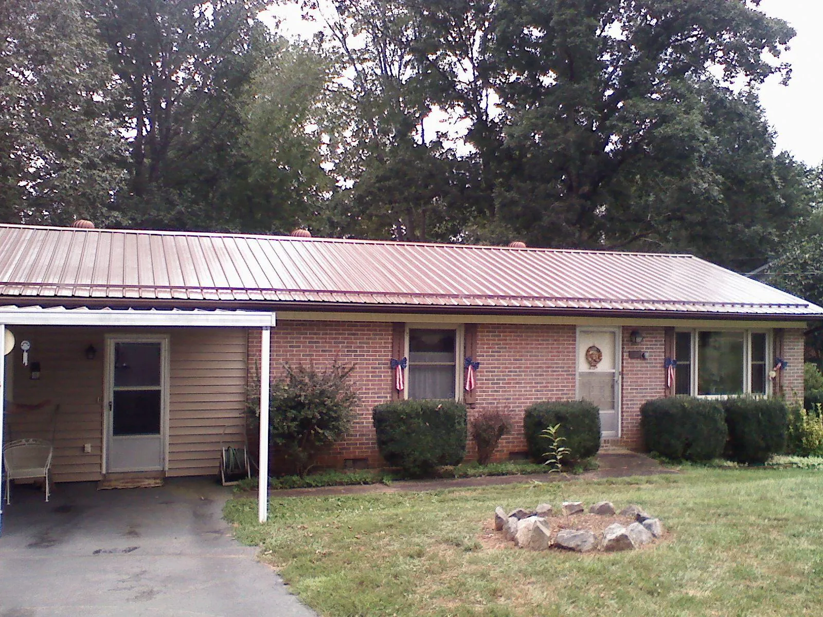 Bronze metal roof and carport on a brick ranch home — Roof Repair work by our crew in Byfield